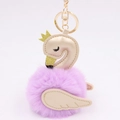 Macro detail of purple plush swan keychain with golden faux leather crown and wing accents - Taro Purple-Champagne