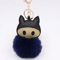 Close-up of fluffy blue pom-pom keychain with black PU leather animal head and gold clasp - Navy Blue
