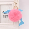 Detailed view of a plush dolphin keychain with pink faux fur and blue leather accents - Deep Pink