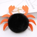 Détail d'un porte-clés crabe en fausse fourrure noire avec pattes en cuir orange et fermoir - Noir