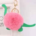 Detail of plush dinosaur keychain with pink fur pompom and green faux leather accents - Dinosaur Style / Deep Pink