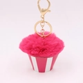 Close-up of pink cupcake pom-pom keychain with golden metal ring and lobster clasp detail - Rose Red