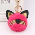 Close-up of pink fluffy cat head keychain with golden whiskers and heart nose detail - Rose Red