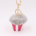 Close-up of grey plush pompom cake keychain with red striped cup and gold hardware - Light Gray