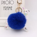 Detailed close-up of white PU leather alpaca keychain with blue fluffy faux fur ball - Sapphire Blue