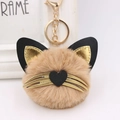 Detail showing plush cat keychain with heart nose, whiskers, and gold metal hardware - Khaki