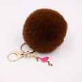 Detailed view of dark brown faux fur pom pom keychain with gold ring and pink flamingo charm - Brown