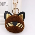 Detail of plush cat keychain with brown fur ball, gold whiskers, and heart nose - Brown