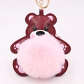 Détail du porte-clés ours en cuir avec pompon rose et anneau en métal doré brillant - Style Chaîne De Clé Or / Rose Clair & Rouge