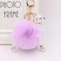 Detailed close-up of purple faux fur pom pom and white alpaca leather pendant with gold clasp - Taro Purple