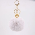 Detailed close-up of a purple faux fur ball keychain with a golden shell and pearl charm - Light Gray