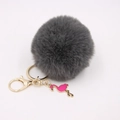 Detail of grey faux fur pom pom keychain with gold lobster clasp and pink flamingo charm - Dark Gray