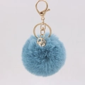 Detailed view of 8cm blue faux rabbit fur keychain with gold crystal geometric pendant - Teal