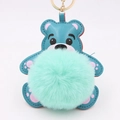Détail d'un porte-clés ours en cuir bleu avec pompon vert menthe doux et anneau doré - Style Chaîne De Clé Or / Vert Menthe & Bleu