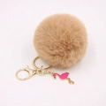 Detail of camel faux fur pom pom keychain with gold ring and pink flamingo charm - Khaki