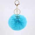 Detail of blue faux fur pompom keychain with golden lobster clasp and starfish charm - Lake Blue