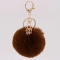 Detail of a brown faux rabbit fur keychain with gold hardware and a geometric gemstone charm - Brown