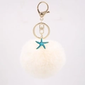 Detailed close-up of cream faux fur pompom keychain with blue starfish and gold clasp - Off-white