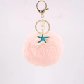 Dettaglio portachiavi con pompon rosa soffice, stella marina e moschettone dorato - Rosa