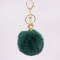 Detail of dark green faux fur pompom keychain with a golden shell and pearl charm - Dark Green