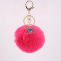 Detail showing a rose pink fluffy pompom keychain with a teal glitter starfish and gold ring - Rose Red