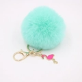 Detailed view of mint green faux fur pompom keychain with golden clasp and pink flamingo - Mint Green