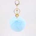 Detail of light blue faux fur pompom keychain with golden shell and pearl charm - Light Blue