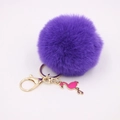Detailed view of soft purple faux fur pompom keychain with golden clasp and pink flamingo - Deep purple