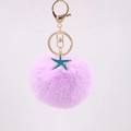 Purple plush pom pom keychain featuring a golden starfish charm and lobster clasp attachment - Taro Purple