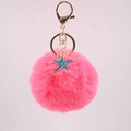 Detail of pink faux fur pompom keychain with golden metal clasp and starfish charm - Watermelon red