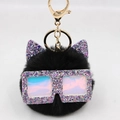 Détail d'un porte-clés chat noir en peluche avec lunettes pailletées et anneau doré - Noir