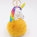 Détail d'un porte-clés licorne en peluche jaune avec crinière arc-en-ciel et pompon doux - Orange