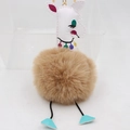 Détail d'un porte-clés girafe avec pompon marron et crochet en métal doré brillant - Khaki