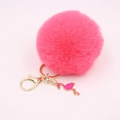 Detail of pink fluffy pompom keychain with golden clasp and cute flamingo pendant charm - Watermelon red