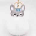 Gros plan du porte-clés pompon chat mignon avec anneau métallique doré et chaîne en métal - Porte-clés Doré / Blanc
