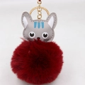 Gros plan du joli porte-clés pompon chat gris avec une chaîne en métal doré élégante - Porte-clés Doré / Bordeaux