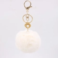 Detail of soft faux fur pompom keychain with golden shell and pearl charm element - Off-white
