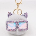 Porte-clés chat en peluche grise avec oreilles pailletées et lunettes irisées sur fond blanc - Gris clair