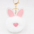 Dettaglio portachiavi a pompon di coniglio bianco con orecchie in pelle rosa e clip dorata - Stile Portachiavi a Orecchio / Bianco
