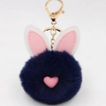 Dettaglio portachiavi a pompon blu navy con orecchie di coniglio e hardware in metallo oro - Stile Portachiavi a Orecchio / Blu Notte