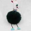 Détail du porte-clés girafe avec tête en cuir blanc, pompon vert et crochet en métal doré - Vert Foncé