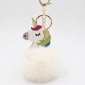 Close-up of a colorful glitter unicorn plush ball keychain with a gold metal clasp - Off White