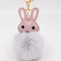 Vue détaillée d'un lapin en cuir PU rose avec pompon gris et porte-clés doré élégant - Gris clair