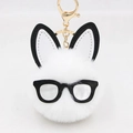 Detailed macro view of white plush pom-pom bunny keychain with black glasses and gold clasp - White