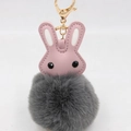 Détail de tête de lapin en cuir PU rose avec pompon gris et fermoir doré brillant - Gris clair