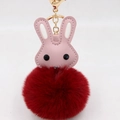 Détail du porte-clés lapin en peluche rouge avec oreilles en cuir et boucle dorée - Bordeaux