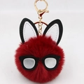 Detail of red plush bunny keychain with sunglasses and golden lobster clasp on white background - Burgundy
