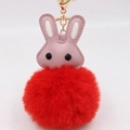 Détail du charme lapin en cuir rose avec pompon rouge et porte-clés en métal doré brillant - Rouge