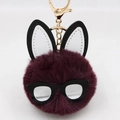 Detailed close-up of a plush bunny keychain with dark purple fur and black-rimmed glasses - Purplish Red