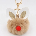 Detail of a brown plush ball keychain with rabbit ears and golden clasp on white background - Bunny Ear Pom Pom Keychain / Khaki